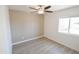 Simple bedroom with ceiling fan, light walls and wood-look floors at 8702 E Boise St, Mesa, AZ 85207