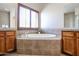 Elegant bathroom with soaking tub, double sinks, and tile flooring at 15817 W Bonitos Dr, Goodyear, AZ 85395