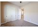 Well-lit bedroom with carpet, large closet, and access to hallway at 15817 W Bonitos Dr, Goodyear, AZ 85395