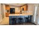 Kitchen with wood cabinets, stainless steel appliances, and breakfast bar at 6349 W Valencia Dr, Laveen, AZ 85339