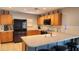 Kitchen boasts wood cabinets, stainless steel appliances, and breakfast bar at 6349 W Valencia Dr, Laveen, AZ 85339