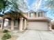 Two-story house with beige exterior, double garage, and landscaping at 15257 W Monroe St, Goodyear, AZ 85338