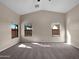 Spacious carpeted bedroom with three windows and a ceiling fan at 42054 W Cheyenne Dr, Maricopa, AZ 85138