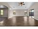 Living room featuring wood-look flooring, sliding glass doors, and high ceilings at 42054 W Cheyenne Dr, Maricopa, AZ 85138