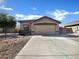 House exterior showcasing a single-story home with a two-car garage and desert landscaping at 42054 W Cheyenne Dr, Maricopa, AZ 85138