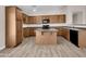 Kitchen boasts wood cabinets, an island, and laminate flooring at 42054 W Cheyenne Dr, Maricopa, AZ 85138