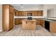 Kitchen features wood cabinets, an island, and laminate flooring at 42054 W Cheyenne Dr, Maricopa, AZ 85138