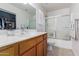 Clean bathroom with a tub, shower, and wooden vanity at 35066 N Happy Jack Dr, San Tan Valley, AZ 85144