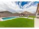 Landscaped backyard with pool, patio furniture, and mountain views at 4455 W Suncup Dr, San Tan Valley, AZ 85144