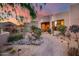 Landscaped backyard patio with a stone fireplace and desert plants at 8300 E Dixileta Dr # 253, Scottsdale, AZ 85266