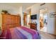 Bedroom with striped bedding, wood furniture, and en-suite bathroom at 8300 E Dixileta Dr # 253, Scottsdale, AZ 85266