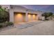 Three-car garage with light-colored doors and desert landscaping at 8300 E Dixileta Dr # 253, Scottsdale, AZ 85266