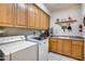 Laundry room with washer, dryer, wood cabinets, and a sink at 8300 E Dixileta Dr # 253, Scottsdale, AZ 85266