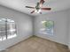 Simple bedroom with neutral decor, ceiling fan, and arched windows at 10030 W Indian School Rd # 257, Phoenix, AZ 85037