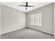 Bright bedroom featuring grey carpet, plantation shutters and ceiling fan at 21655 N 36Th Ave # 104, Glendale, AZ 85308