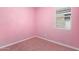 Bedroom with pink walls, carpet, and a window at 40486 W Sunland Dr, Maricopa, AZ 85138