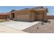 Tan house with two car garage and desert landscaping at 11225 E Ocaso Ave, Mesa, AZ 85212