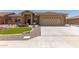 Tan house with a three-car garage and landscaped front yard at 11225 E Ocaso Ave, Mesa, AZ 85212