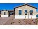 Front exterior of a home with desert landscaping, a paved driveway, and decorative trees at 16348 W Avenida Del Sol --, Surprise, AZ 85387
