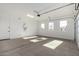 Two-car garage with a partially opened garage door and windows at 16348 W Avenida Del Sol --, Surprise, AZ 85387