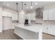 Modern white kitchen with a large island, stainless steel appliances, and pendant lighting at 16348 W Avenida Del Sol --, Surprise, AZ 85387