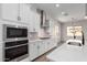 White kitchen with stainless steel appliances, quartz countertops, and modern black faucet at 16348 W Avenida Del Sol --, Surprise, AZ 85387
