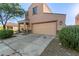 Two-story house with tan exterior, two-car garage, and landscaping at 8690 S 253Rd Ave, Buckeye, AZ 85326