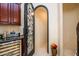 Elegant wine cellar with arched door and custom cabinetry at 9233 S Krista E Dr, Goodyear, AZ 85338