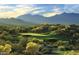 Aerial view of a golf course with mountain backdrop at 9233 S Krista E Dr, Goodyear, AZ 85338