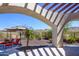 Landscaped backyard with pergola and seating area at 9233 S Krista E Dr, Goodyear, AZ 85338