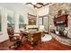 Home office with wood desk, fireplace and hardwood floors at 9233 S Krista E Dr, Goodyear, AZ 85338