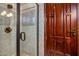 Bathroom with a tiled shower and a wooden door at 9233 S Krista E Dr, Goodyear, AZ 85338