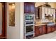 Built-in double oven and microwave in a spacious kitchen with dark wood cabinets at 9233 S Krista E Dr, Goodyear, AZ 85338