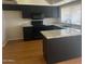 Modern kitchen with dark cabinetry, granite countertops, and hardwood floors at 4327 E San Gabriel Ave, Phoenix, AZ 85044