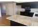 Modern kitchen with dark cabinetry, granite countertops, and hardwood floors at 4327 E San Gabriel Ave, Phoenix, AZ 85044