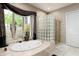 Spa-like bathroom with a soaking tub, glass shower, and natural light at 6545 N 29Th St, Phoenix, AZ 85016