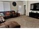 Open living room showcasing a comfortable sectional sofa and flat-screen TV at 30253 W Earll Dr, Buckeye, AZ 85396