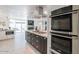 Modern kitchen with double ovens, granite countertops, and stainless steel appliances at 7344 E Keim Dr, Scottsdale, AZ 85250