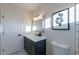 Stylish bathroom with dark vanity, white tile, and a large mirror at 7344 E Keim Dr, Scottsdale, AZ 85250