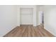 Well-lit bedroom featuring wood-look floors and built-in closet at 2653 N 118Th Ave, Avondale, AZ 85392