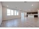 Living room with tile floors, kitchen view, and sliding glass doors at 18128 W Daley Ln, Surprise, AZ 85387