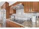 Modern cooktop and wooden cabinetry feature in this updated kitchen at 11801 S 193Rd Dr, Buckeye, AZ 85326