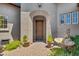 Front entrance of the home with a wooden door and brick walkway, featuring a fountain at 8874 E Flathorn Dr, Scottsdale, AZ 85255
