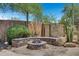 Landscaped backyard with a stone fire pit and seating at 8874 E Flathorn Dr, Scottsdale, AZ 85255