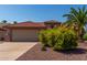 Tan house with terracotta roof, yellow flowers, and palm tree at 15631 W Bethesda Ct, Surprise, AZ 85374