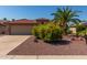Tan house with terracotta roof, yellow flowers, and palm tree at 15631 W Bethesda Ct, Surprise, AZ 85374