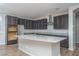 Modern kitchen with granite island, stainless steel appliances and dark gray cabinetry at 16062 W Alameda Rd, Surprise, AZ 85387