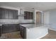 Modern kitchen with granite island, stainless steel appliances and dark gray cabinetry at 16062 W Alameda Rd, Surprise, AZ 85387