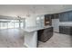 Open kitchen boasts a granite island, stainless steel appliances, and dark gray cabinets at 16062 W Alameda Rd, Surprise, AZ 85387