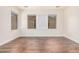 Well-lit bedroom featuring wood-look floors and large windows at 5713 W Rowel Rd, Phoenix, AZ 85083